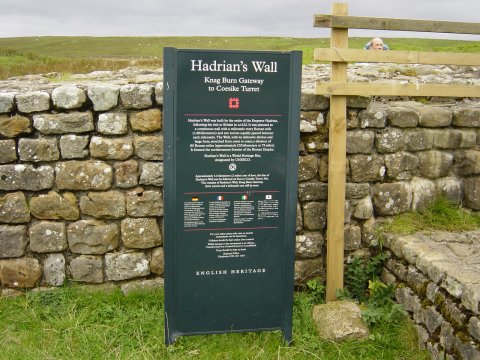 It reads:- HADRIANS WALL, KNAG BURN GATEWAY TO COESITE TURRET. Hadrian's wall was built by order of the emperor Hadrian, following his visit to Britain in AD 122. It was planned as a continuous wall with a milecastle every Roman mile (1.48 Kilometres) and two turrets equally spaced between each milecastle. The wall with its defense ditches and large forts, streched from coast to coast, a distance of 80 Romain miles (approx 120 kilometres or 75 miles). It formed the northern frontier of the Roman empire.